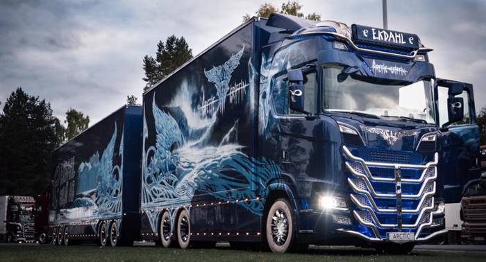 En mörkblå stor lastbil med eldliknande motiv i vitt framtill.
